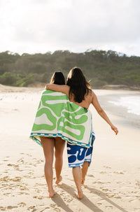 Lost Sol Byron Bay Pastel beach towel in soft eucalyptus green in use on holiday, lifestyle photo