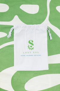 Compact packable Lost Sol Byron Bay Pastel microfibre towel in soft eucalyptus green, lifestyle photo