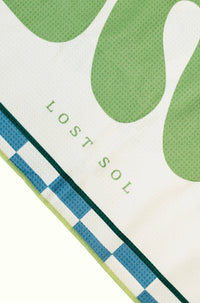Byron Bay Pastel quick-dry microfibre towel in soft eucalyptus green, folded product shot on a yellow background