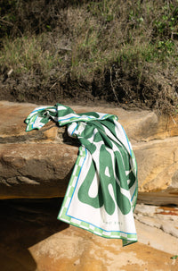 Byron Bay Bold deep green beach towel shaking sand-free on the beach, Lost Sol lifestyle photo