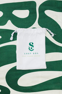 Compact packable Lost Sol Byron Bay Bold microfibre towel in deep green, lifestyle photo
