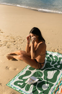 Lost Sol Byron Bay Bold beach towel in deep green in use on holiday, lifestyle photo