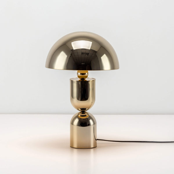 A reflective brass metal dome containing integrated LED bulbs forms the top of the mushroom-shaped table lamp. Light is off.