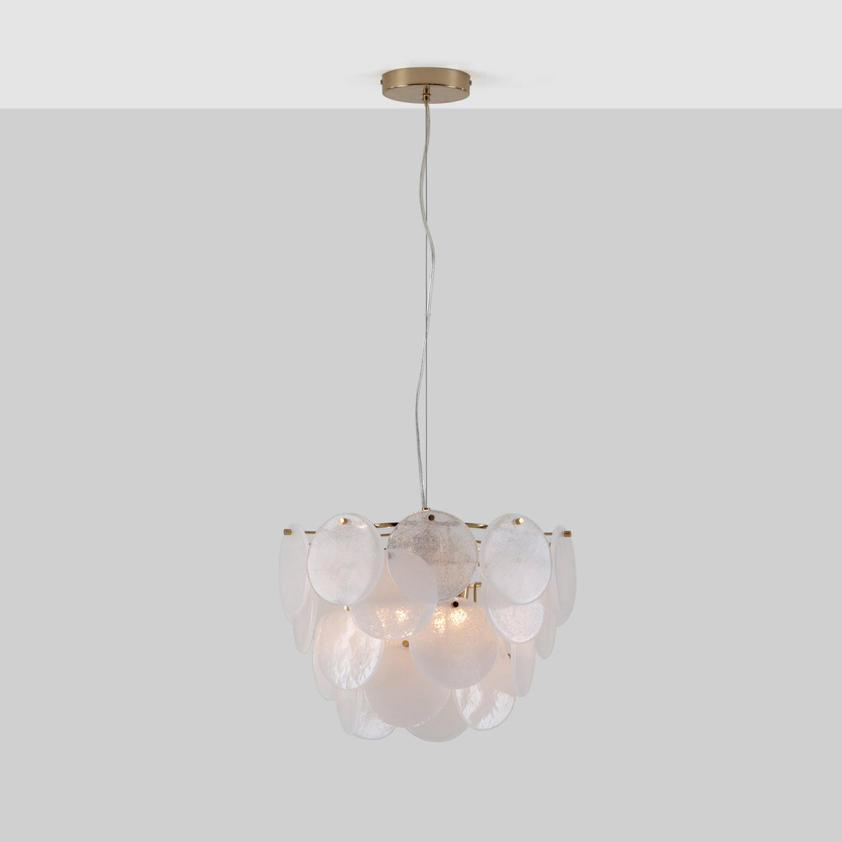 A brass frame suspends circular frosted glass pieces over 4 tiers. The light is switched on.