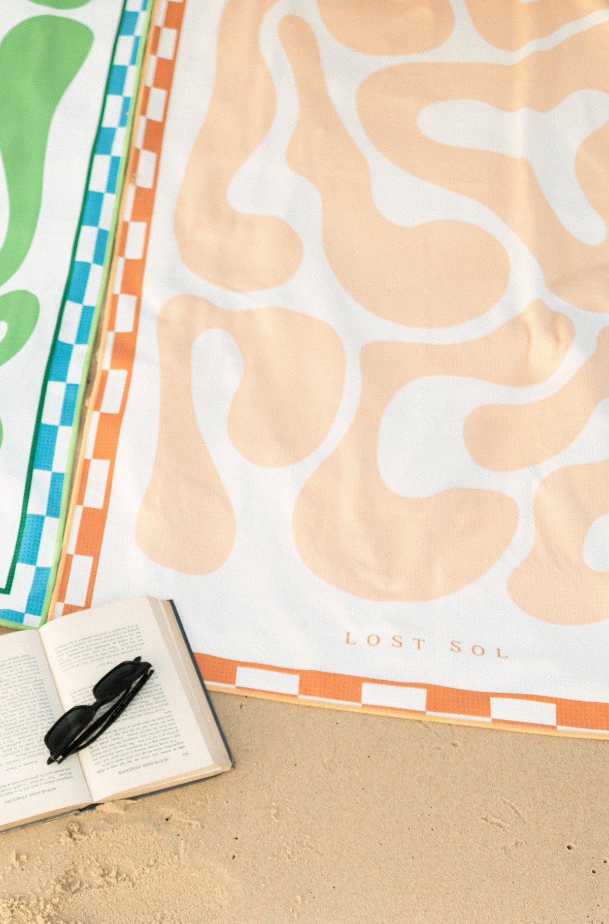 Mallorca Pastel soft peach beach towel shaking sand-free on the beach, Lost Sol lifestyle photo