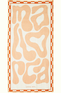 Mallorca Pastel sand-free beach towel in soft peach by Lost Sol, laid flat on a yellow background