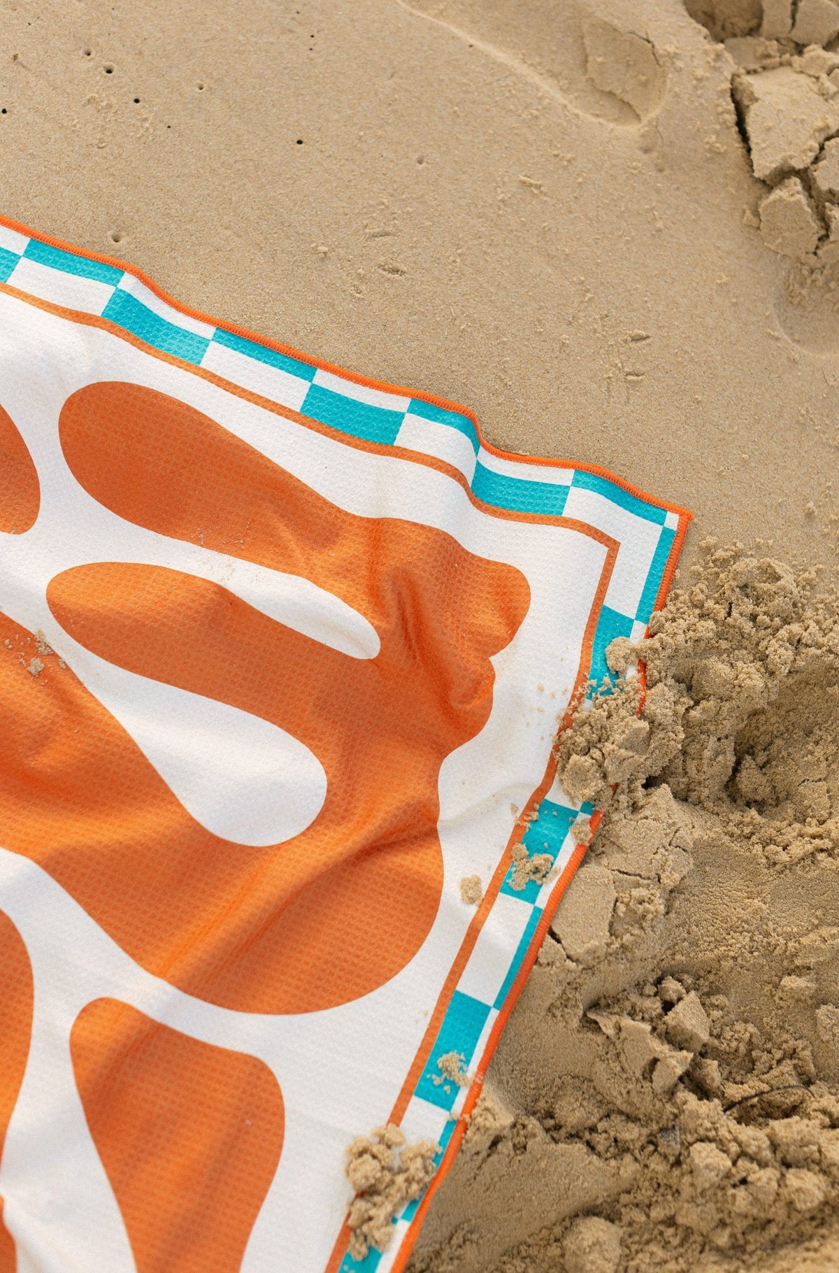 Mallorca Bold burnt orange beach towel shaking sand-free on the beach, Lost Sol lifestyle photo