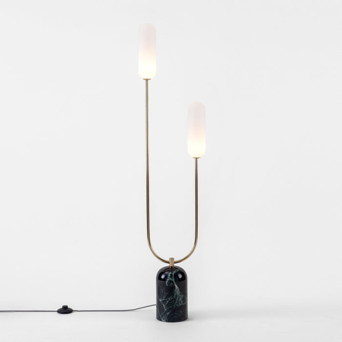 A solid green marble base holds a U-shaped curve brass arm with two oblong glass shades at either end. Lights on.