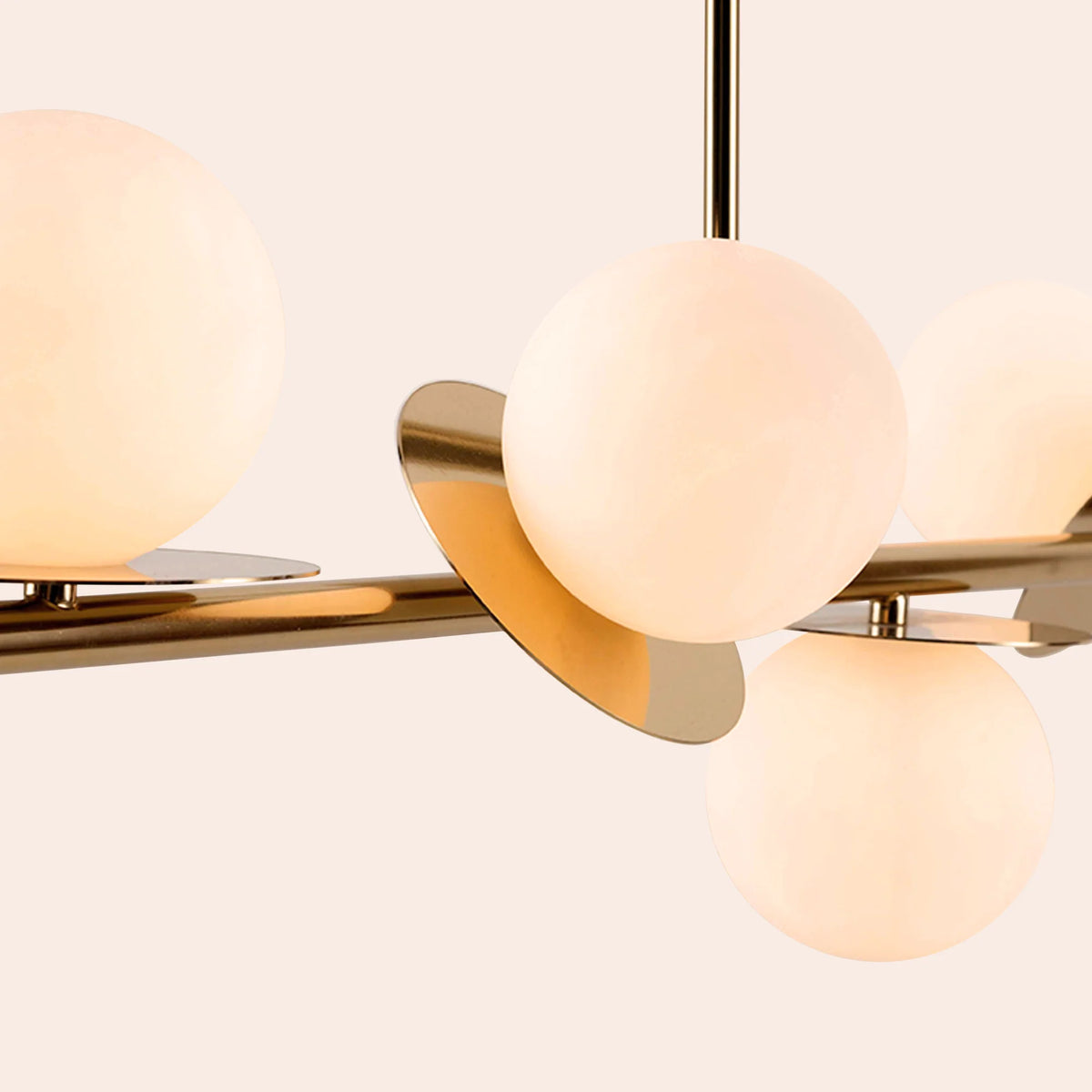 Brass Opal Disk Ceiling Light . A horizontal brass metal stems holds 4 metal disks at varying angles, each topped with an opal glass shade. Light is on.