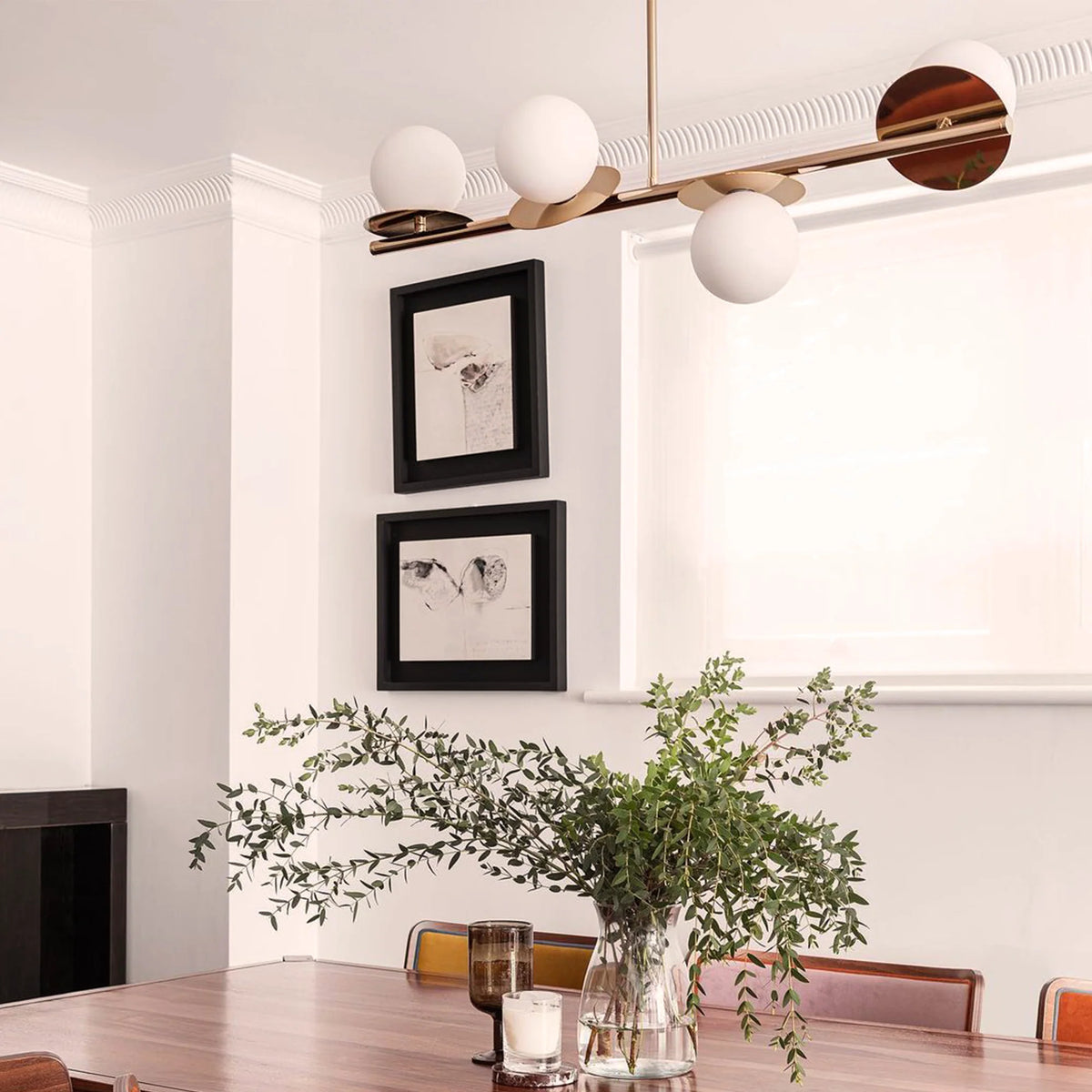 Brass Opal Disk Ceiling Light . A horizontal brass metal stems holds 4 metal disks at varying angles, each topped with an opal glass shade. Light is on.