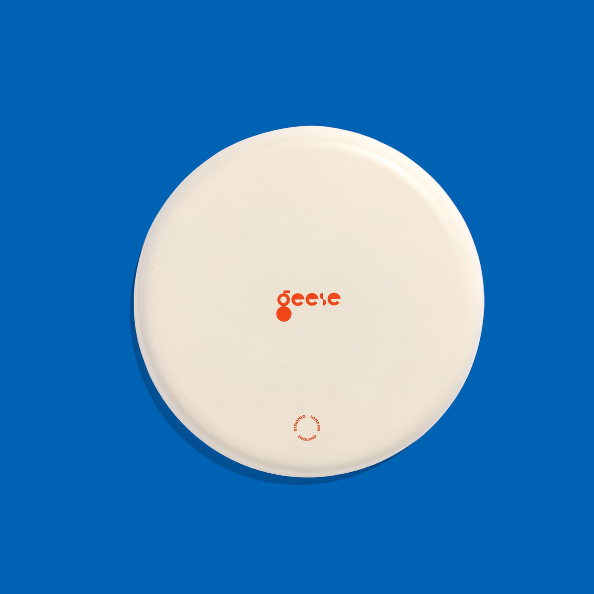 Zeppelin round enamel tray in grey with a contrast blue cross design by Geese