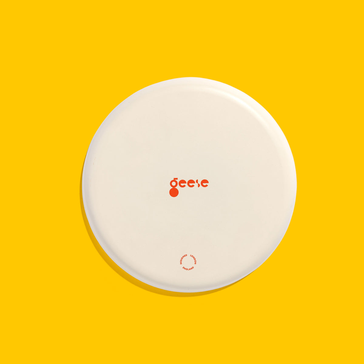 Zeppelin round enamel tray in blue with a vibrant yellow cross design by Geese