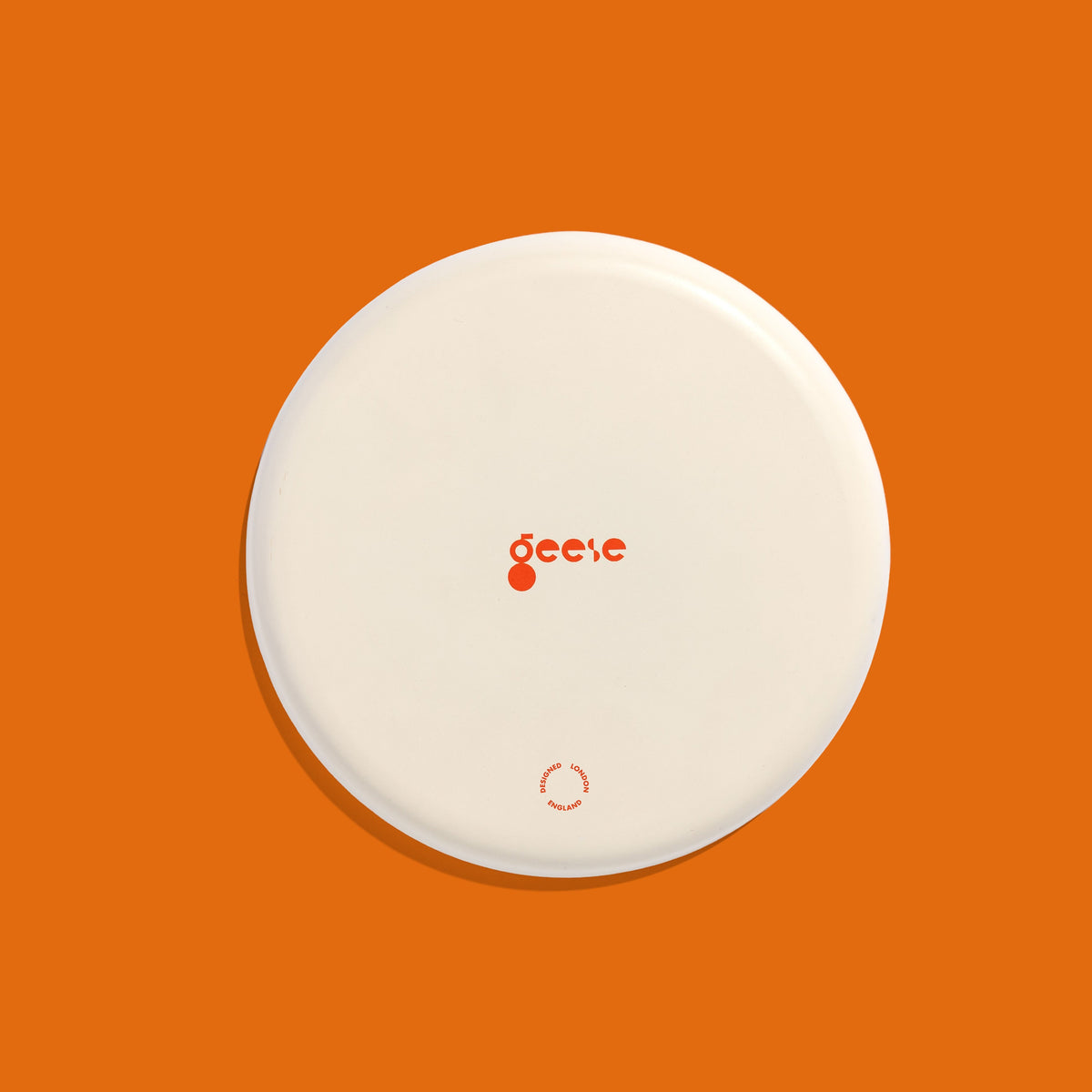 Zodiac round enamel tray in cream with an orange star and blue rim by Geese