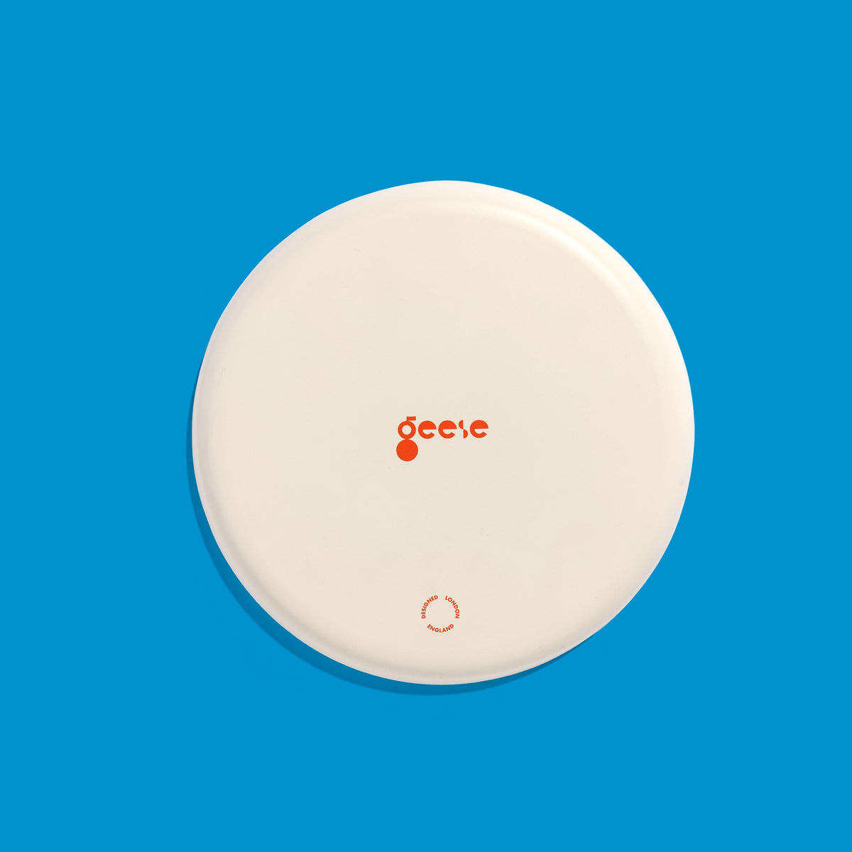 Zone round enamel tray in cream with a large blue cross by Geese