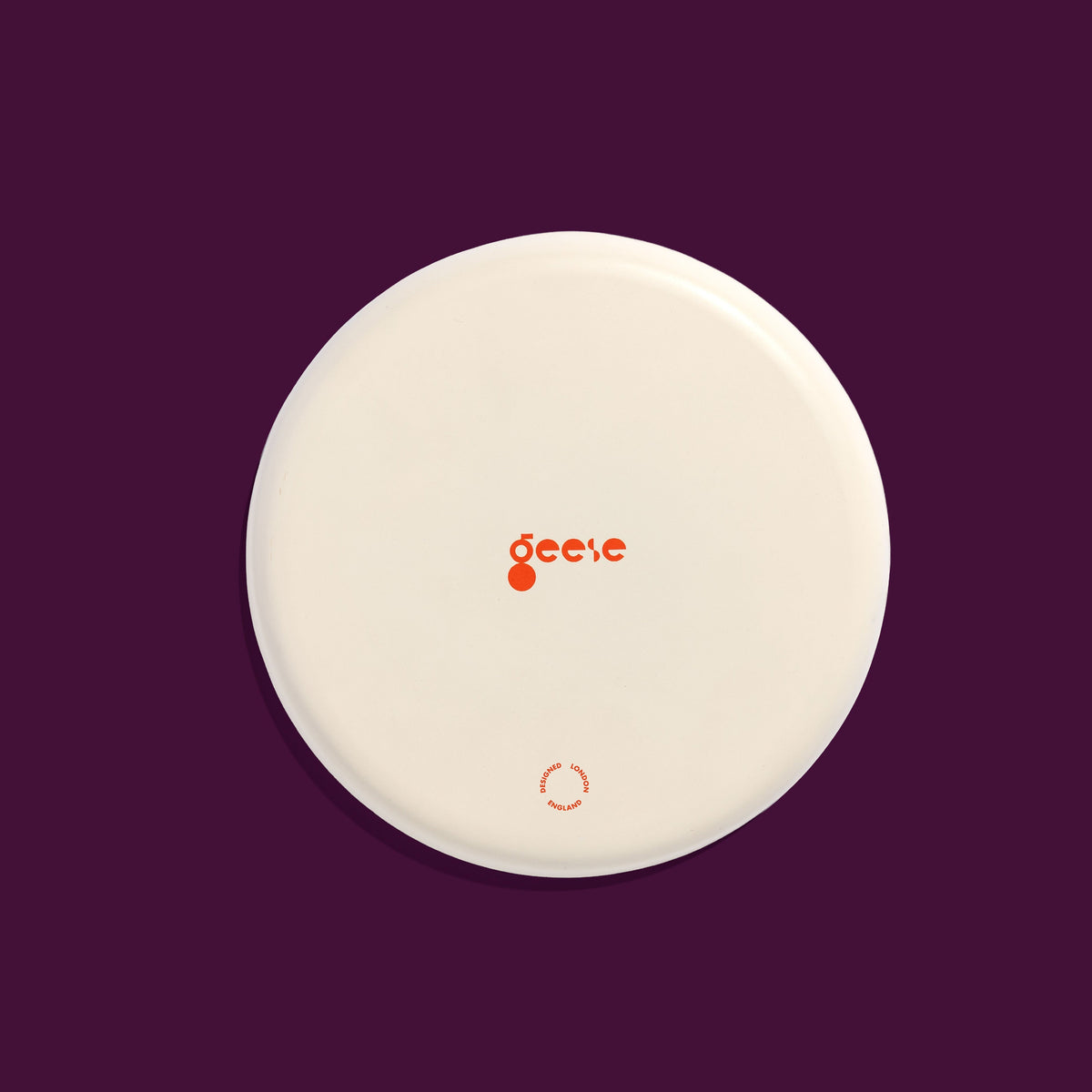 Zilla round enamel tray in pink with an abstract purple splash design by Geese