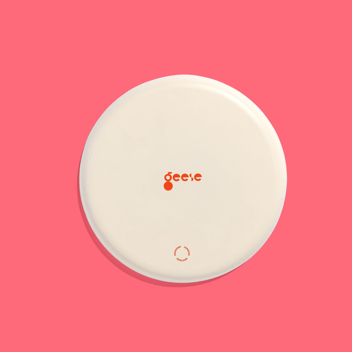 Zoom round enamel tray with multicoloured circles in orange, blue, black and pink by Geese