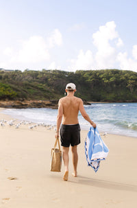 Lost Sol Santorini Pastel beach towel in soft sky blue in use on holiday, lifestyle photo