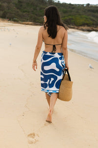 Santorini Bold deep blue and white beach towel shaking sand-free on the beach, Lost Sol lifestyle photo
