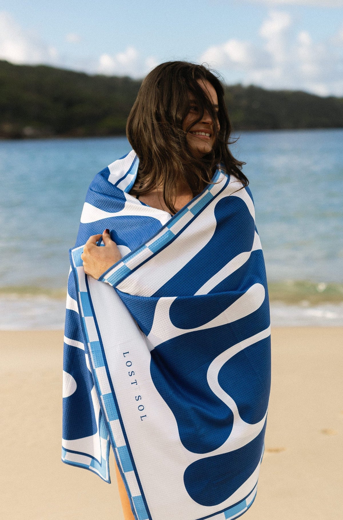 Lost Sol Santorini Bold beach towel in deep blue and white in use on holiday, lifestyle photo