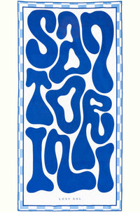 Santorini Bold sand-free beach towel in deep blue and white by Lost Sol, laid flat on a yellow background