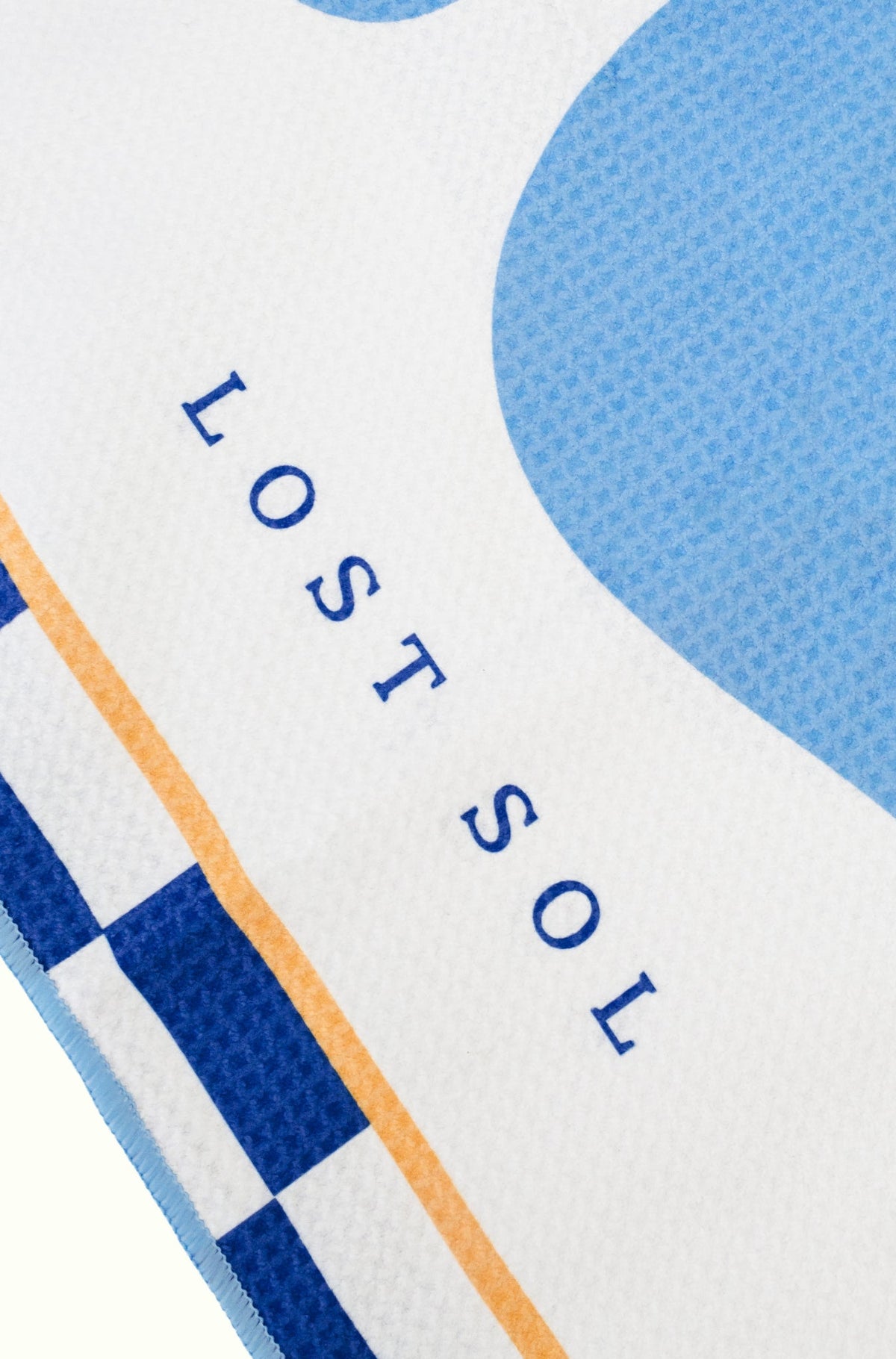 Santorini Pastel quick-dry microfibre towel in soft sky blue, folded product shot on a yellow background