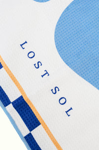 Santorini Pastel quick-dry microfibre towel in soft sky blue, folded product shot on a yellow background