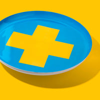 Zeppelin round enamel tray in blue with a vibrant yellow cross design by Geese