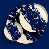 Zero round enamel tray in cream with a large abstract dark blue splash by Geese