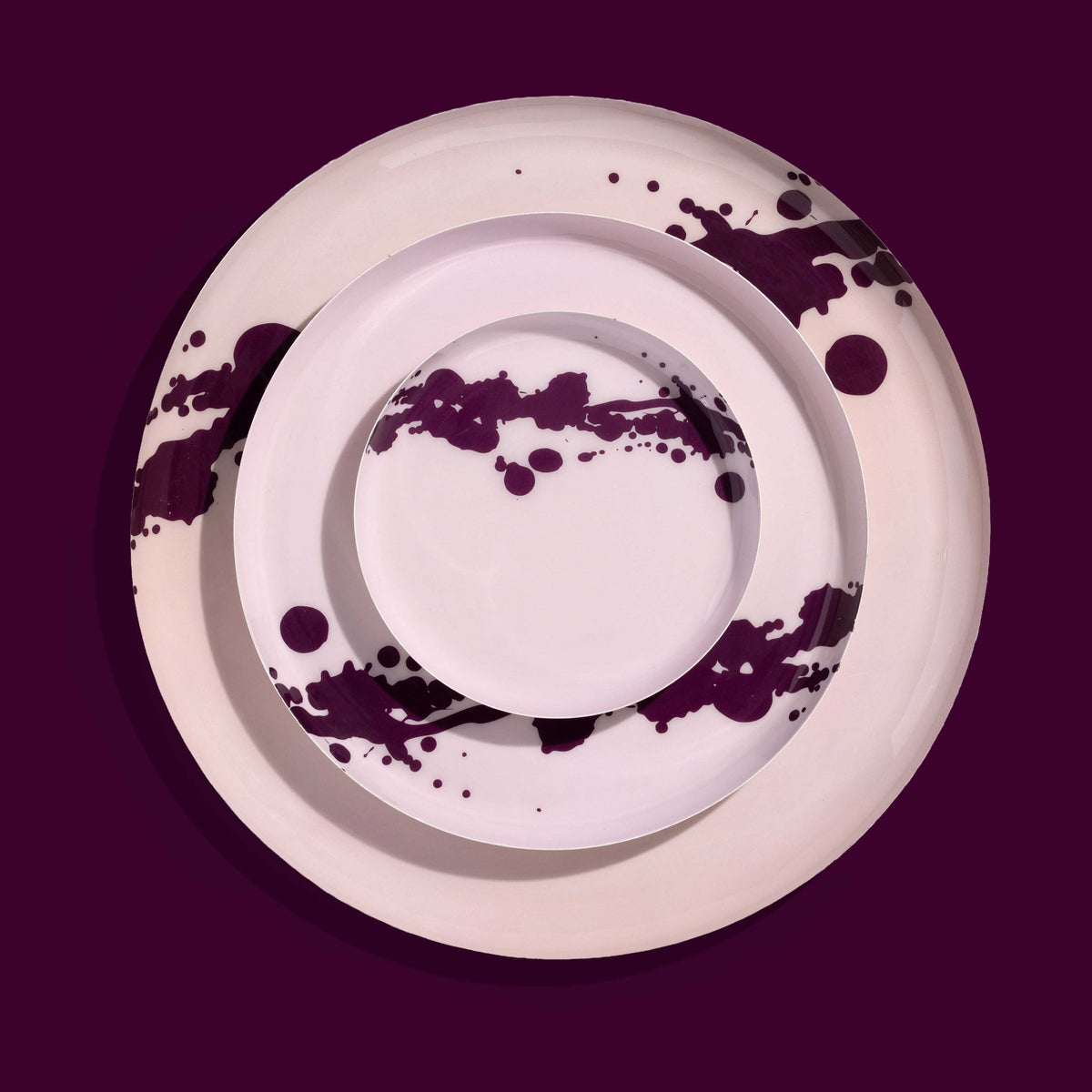 Zilla round enamel tray in pink with an abstract purple splash design by Geese