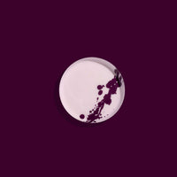 Zilla round enamel tray in pink with an abstract purple splash design by Geese