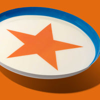 Zodiac round enamel tray in cream with an orange star and blue rim by Geese