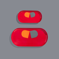 Zombie capsule enamel tray in deep red with an orange and grey split pill design by Geese