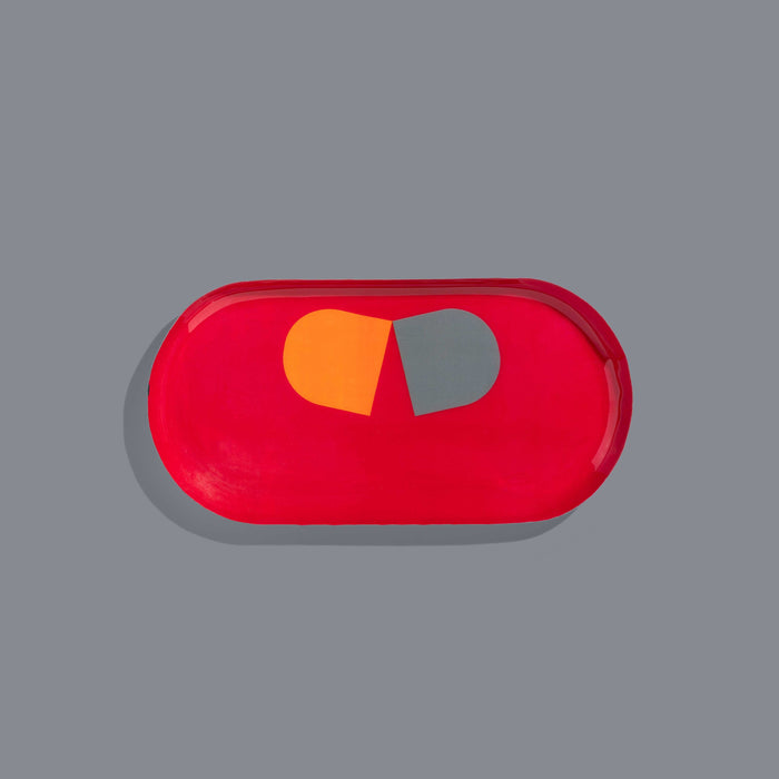 Zombie capsule enamel tray in deep red with an orange and grey split pill design by Geese
