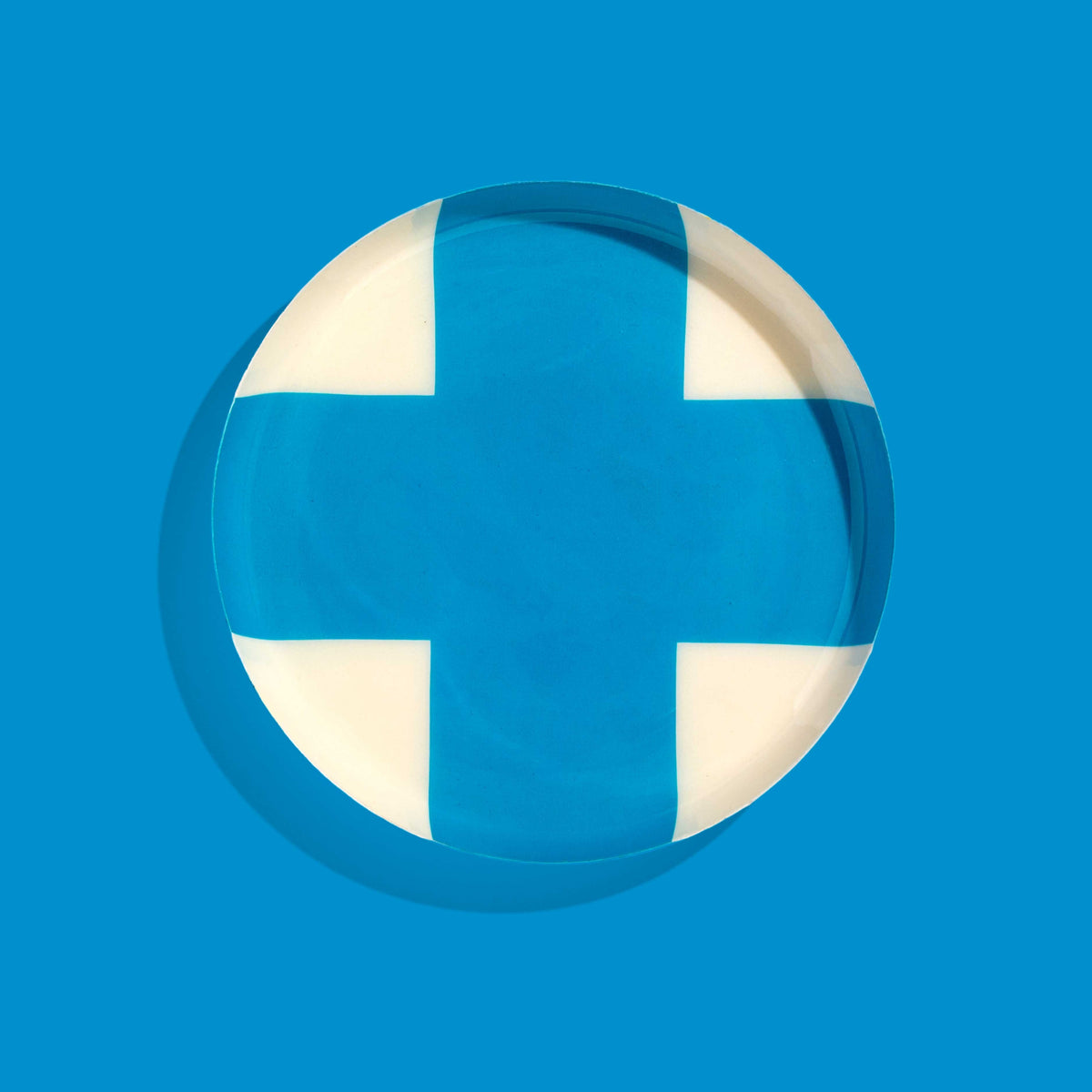 Zone round enamel tray in cream with a large blue cross by Geese