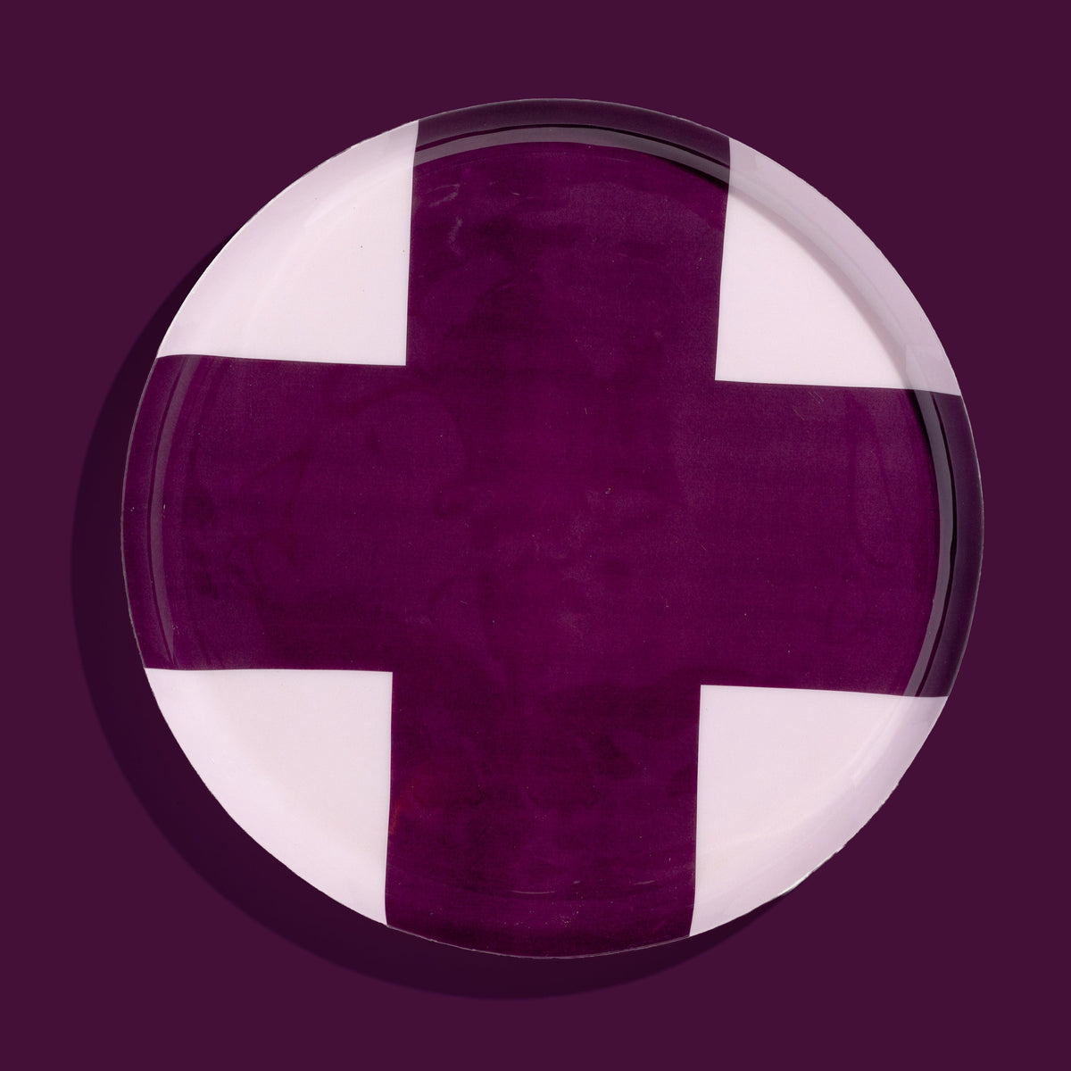 Zone round enamel tray in pink with a large purple cross by Geese
