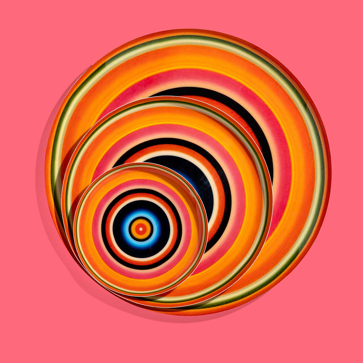 Zoom round enamel tray with multicoloured circles in orange, blue, black and pink by Geese
