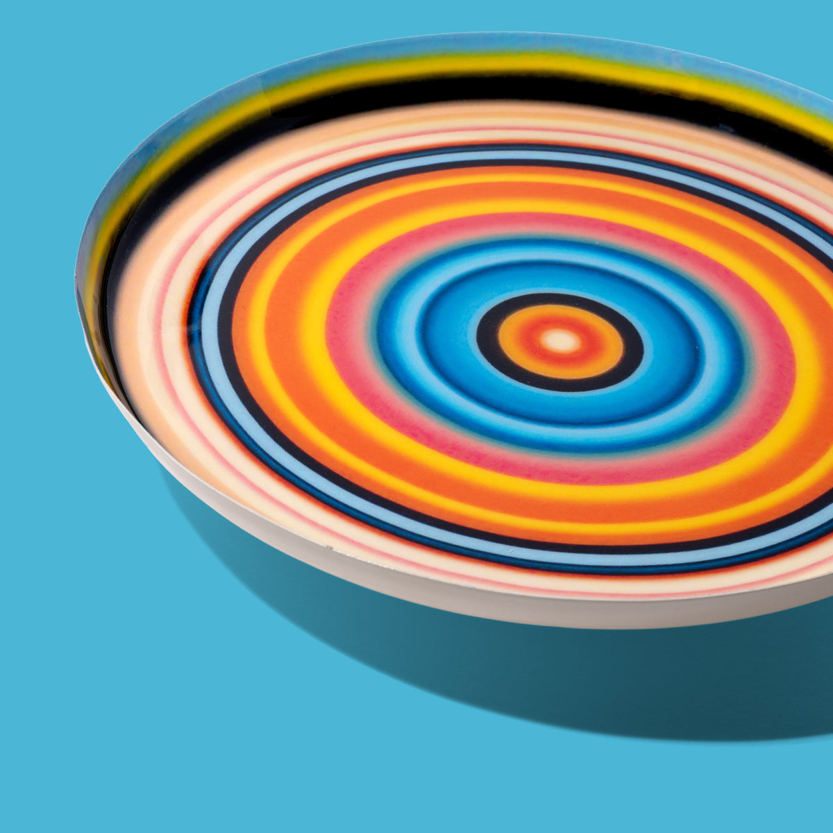 Zoom round enamel tray with multicoloured circles in pink, blue, orange, yellow and black by Geese
