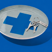 Zeppelin round enamel tray in grey with a contrast blue cross design by Geese